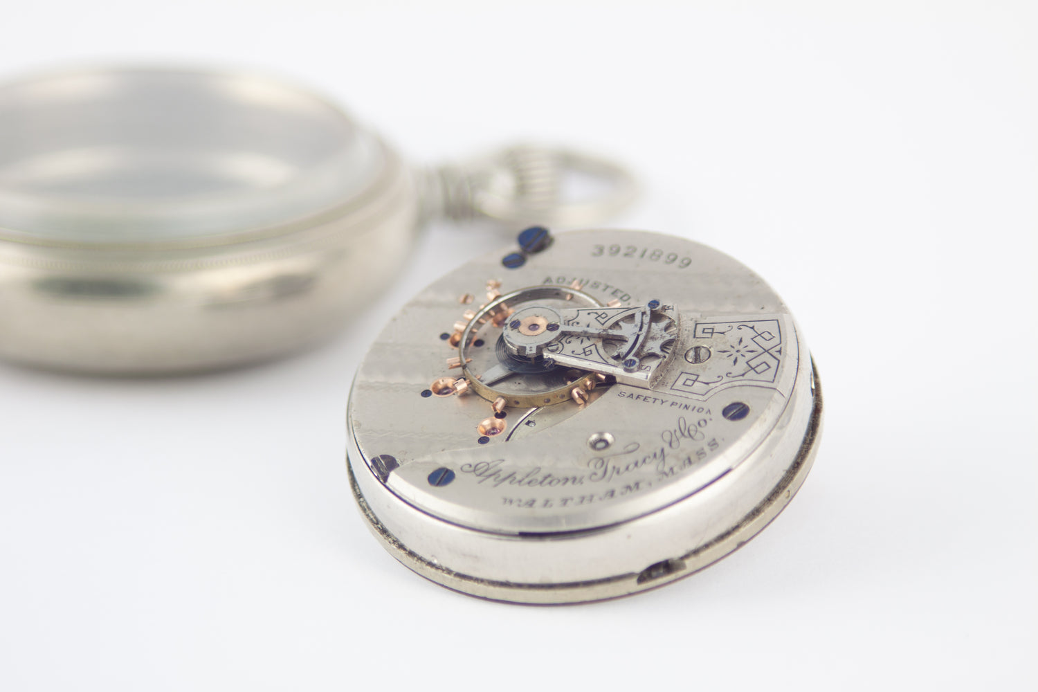 Waltham pocket watch movement shown next to pocket watch case.